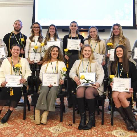 A group of occupational therapy students poses wearing their honor cords